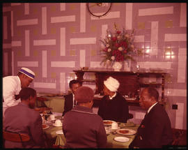 Group of people being served in dining room.