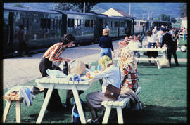 Port Elizabeth district, 1978. People having picnic on station platform alongside passenger train.