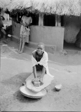 Northern Transvaal, 1934. Young girl grinding corn.