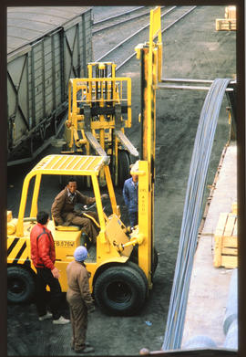 
Forklift loading steel reinforcing bars onto railway wagon.
