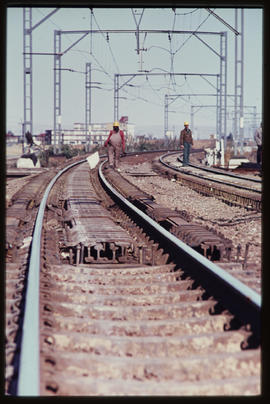 Steel rails clamped between railway tracks on curve.