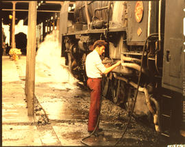 Kimberley, July 1978. Fireman flushing out ash pan of SAR Class 25NC No 3517 in locomotive shed. ...