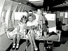
SAA Boeing 707 interior. Cabin service. Mother and young girl and boy.
