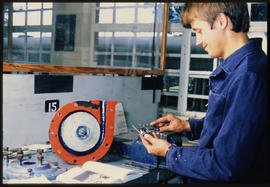 Technician measuring bearing with micrometer.