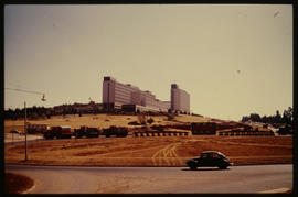 Pretoria, August 1976. SAR International Pacific trucks with abnormal load passing Iscor headquar...