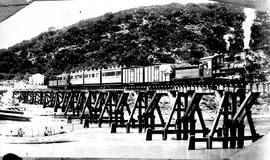 Humansdorp district. Train crossing wooden bridge over the Gamtoos River, hauled by Class SAR NG ...