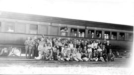 
Tour group posing with train. Photographs taken during Round-in-Nine tour.
