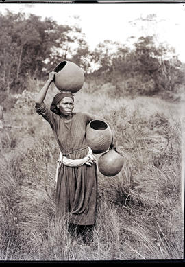 Natal South Coast, 1934. Zulu woman caryring pots to be baked.