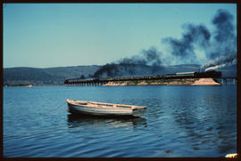 Knysna, 1989. Steam locomotives with passenger train on bridge over Knysna lagoon.