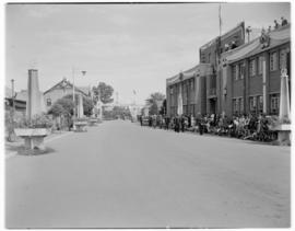 Kimberley, 18 April 1947.  Crowd along road with welcoming arch in the distance.
