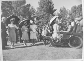 Royal family in a stadium with a three-wheel Nelco Solocar electric invalid carriage.