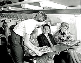 
SAA Boeing 707 hostess serving passengers.
