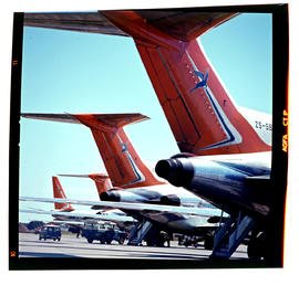 Three SAA Boeing 727 aircraft on tarmac. Note Land Rover and Mini.