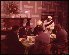 Group of people being served in dining room.