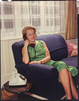 
Woman speaking on new dial phone.
