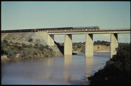 Passenger train on concrete bridge.