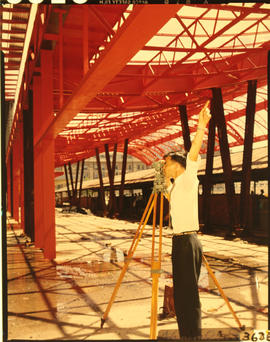 Civil engineer surveying steel structure.
