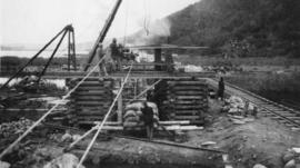 Wilderness, circa 1926. Duive River bridge construction: Pile screwing from sleeper cribs. (Colle...