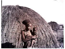 Natal, 1949. Zulu woman with child in front of hut.