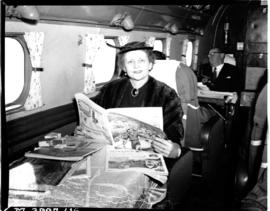 November 1955. Lockheed Lodestar interior. Woman reading newspaper.