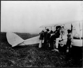 De Haviland DH.80 Gipsy Moth Aircraft on ground with seven people.