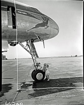 
SAA Lockheed Constellation ZS-DBT 'Pretoria'. Little boy and girl standing at nose wheel.
