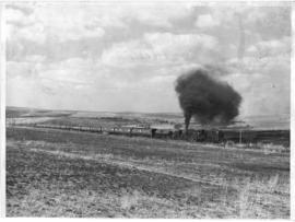 Magaliesburg. Steam train with village in the distance.