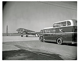 Cape Town, 1949. Wingfield airport. SAA Douglas DC-3 ZS-BXF 'Klapperkop' with Commer Commando bus.