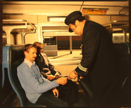 May 1981. Conductor checking tickets in passenger train. [D Dannhauser]