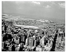 Johannesburg, 1960. SAA Boeing 707 ZS-CKC 'Cape Town' over city. Note painted engines.