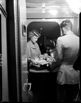 
SAA Douglas DC-4 interior, hostess with tray of food. Steward.
