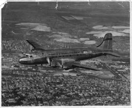 Johannesburg. SAA Douglas DC-4 ZS-AUB 'Outeniqua' in flight. Note flying springbok roundel. See L...
