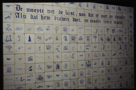 Dutch proverbs on tiled mural.