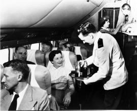 
SAA Douglas DC-7B interior. Flight steward talking to passengers. Uniform from 1946–1958.
