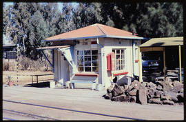 August 1994. Small station building with load of rocks alongside railway tracks.