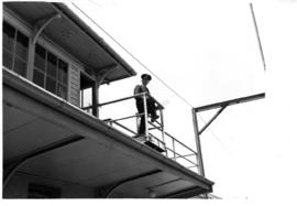 Mechanical signal cabin cabin with man on balcony.