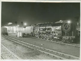 SAR Class 25NC on passenger train at night at railway station.