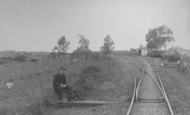 Amalinda, 1895. Small station building in the distance with railwayman sitting at points in the f...
