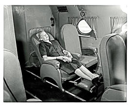 
SAA Douglas DC-4 interior with passenger in reclining chair.
