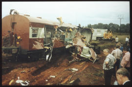Severely damaged railway coach on accident scene.