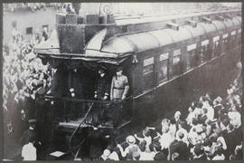 Crowd surrounding special train at station platform.