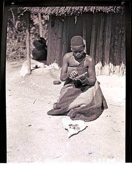 Northern Transvaal, 1934. Sesotho woman threading beads.