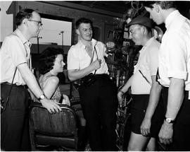 Four men and woman in mechanical control room.