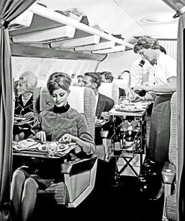 
SAA Boeing 707 interior. Enjoying a meal. Hostess.
