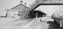 De Aar, 1895. Station building with pedestrian bridge over rails. (EH Short)