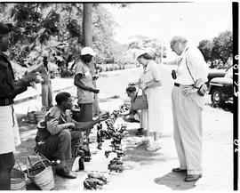 Livingstone, Northern Rhodesia, 1950. Visitors with curio sellers.