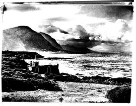 Hermanus, 1948. Cottage on the rocks on coastline.