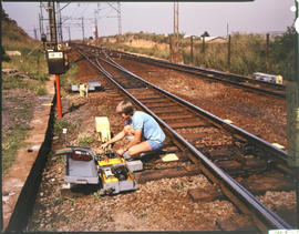 Technician taking measurements at railway track.