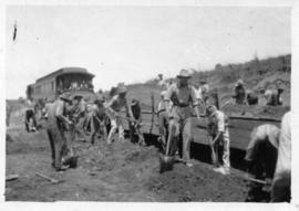 Workers preparing railway track with passenger coach in the background. (Lund collection)