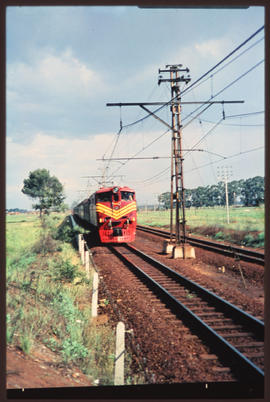 Passenger train on double track in open veld.